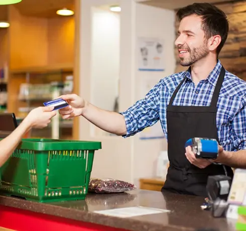 Man taking a credit card from a customer in a retail store